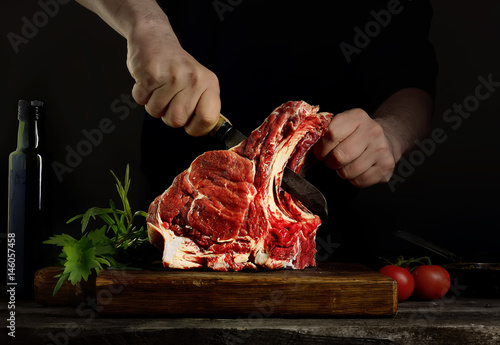 Man cutting raw beef meat.