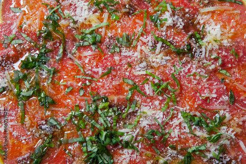 Beef carpaccio served with ruccola on a white plate