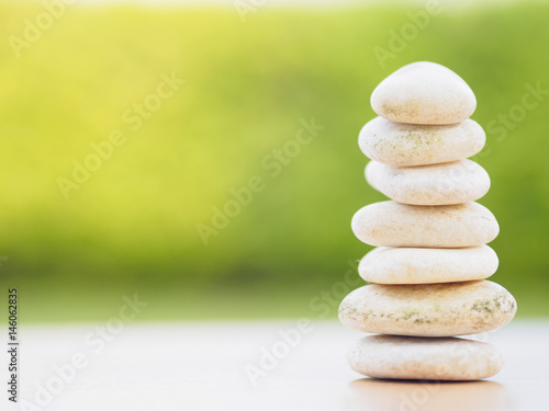 Balance Stones stacked to pyramid in the soft green background to Spa ideas design or freedom and stability concept on rocks.