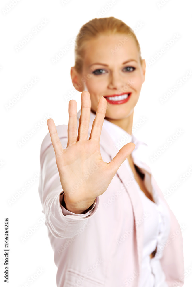 Smiling business woman showing stop sign to the camera Smiling business woman showing stop sign to the camera