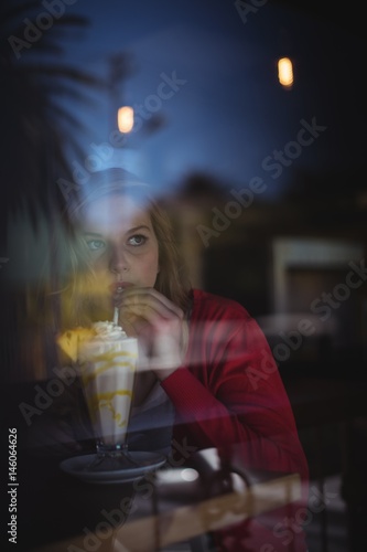Thoughtful woman having milkshake