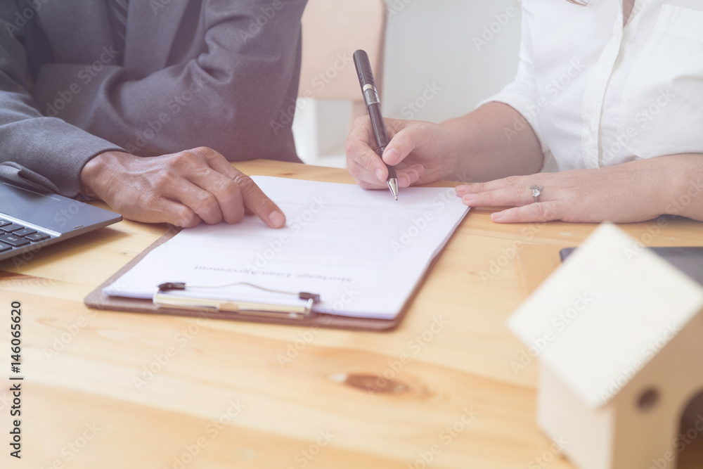 Person's hand hold ballpoint pen writing on agreement paper sheet, fill in document template, applying for mortgage loan Person's hand hold ballpoint pen writing on agreement paper sheet, fill in document template, applying for mortgage loan