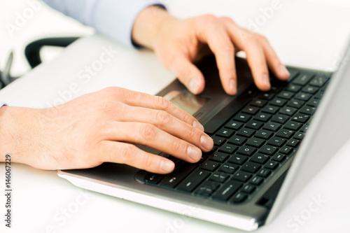 close up of male hands with laptop typing