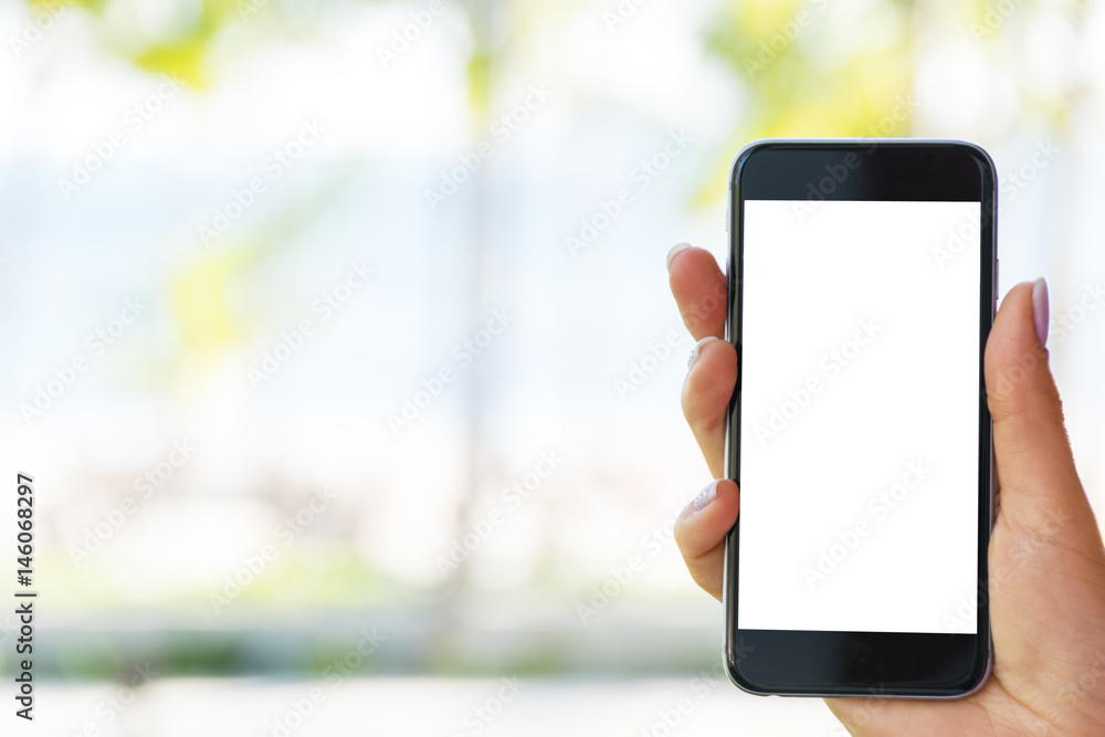 Beautiful woman's hand using smart phone at beach. Smartphone white screen.Blank empty screen