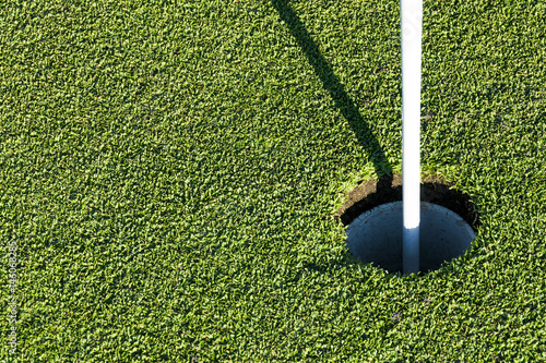 Golf hole on green grass of golf course. View of golf hole on green field