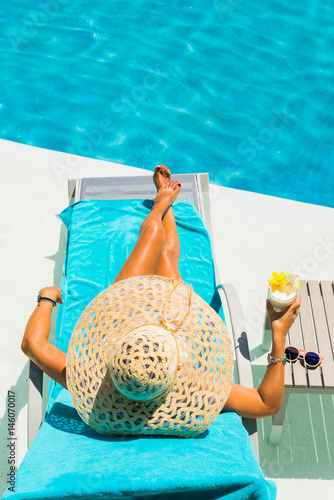 Woman at the poolside with pina colada cocktail photo