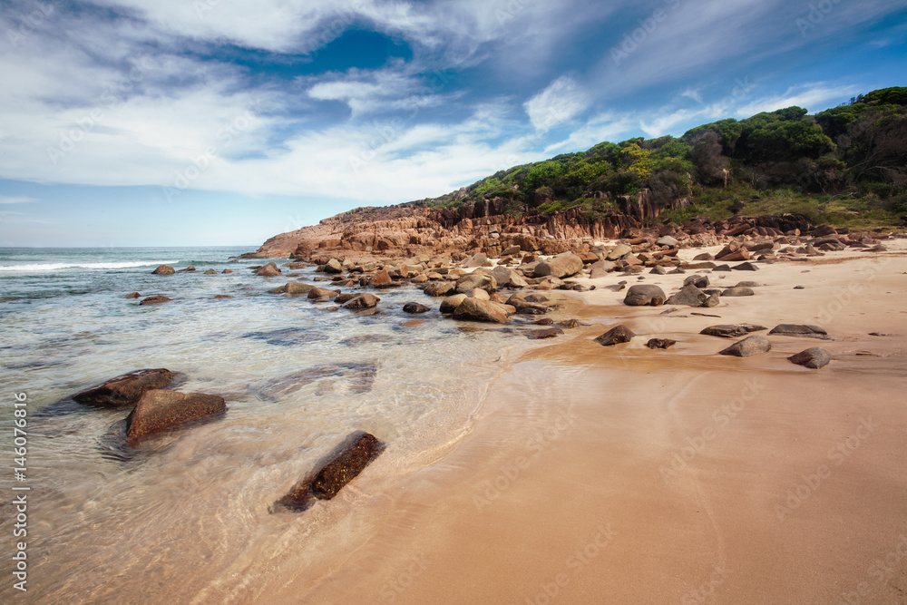 beautiful kingsley beach, with his red rocks wild and deserted in a sunny day ,NSW,  Australia.