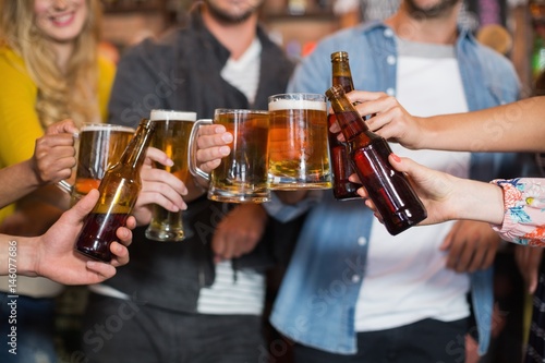 Friends toasting beer glasses and bottles in pub © WavebreakMediaMicro