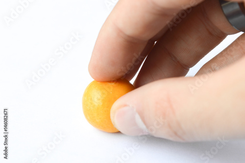 hand holding orane gum isolated on white