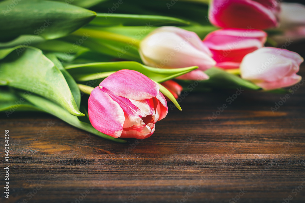 Bouquet of pink tulips on brown wooden background. Top view, copy space. Happy mother's day.