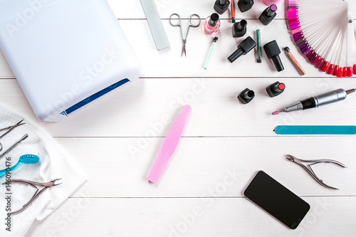 Manicure set and nail polish on wooden background