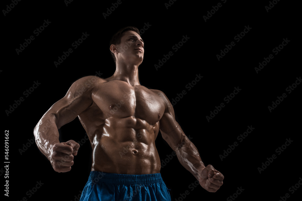 Muscular and fit young bodybuilder fitness male model posing over black background. Muscular and fit young bodybuilder fitness male model posing over black background.