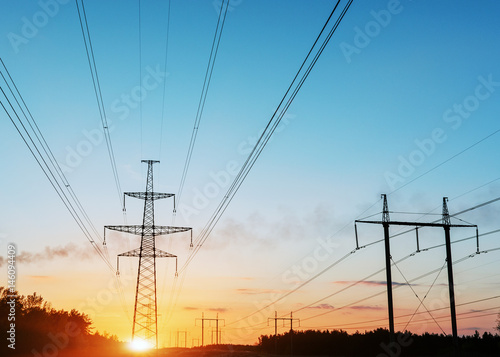 high-voltage power lines at sunset. electricity distribution station.