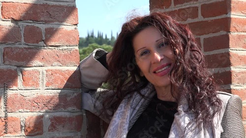 menopausal woman near brick battlements in Italy
