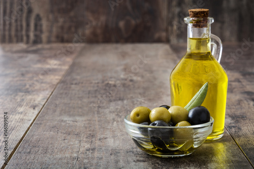 Virgin olive oil in a crystal bottle on wooden background
