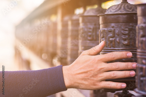 abstract background of hand rolling prayer wheels with lens flare, Buddhist belief