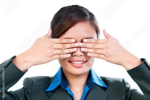 Young corporate woman covering eyes with both her hands over white background