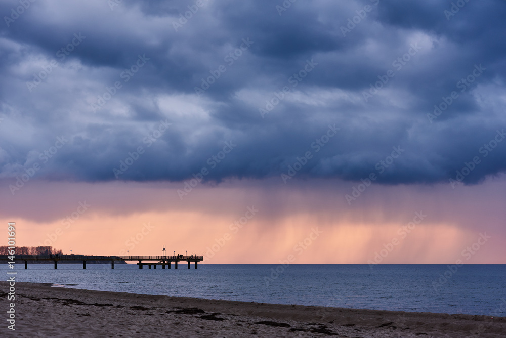 Dunkle Regenwolken über der Seebrücke Rerik, Deutschland.