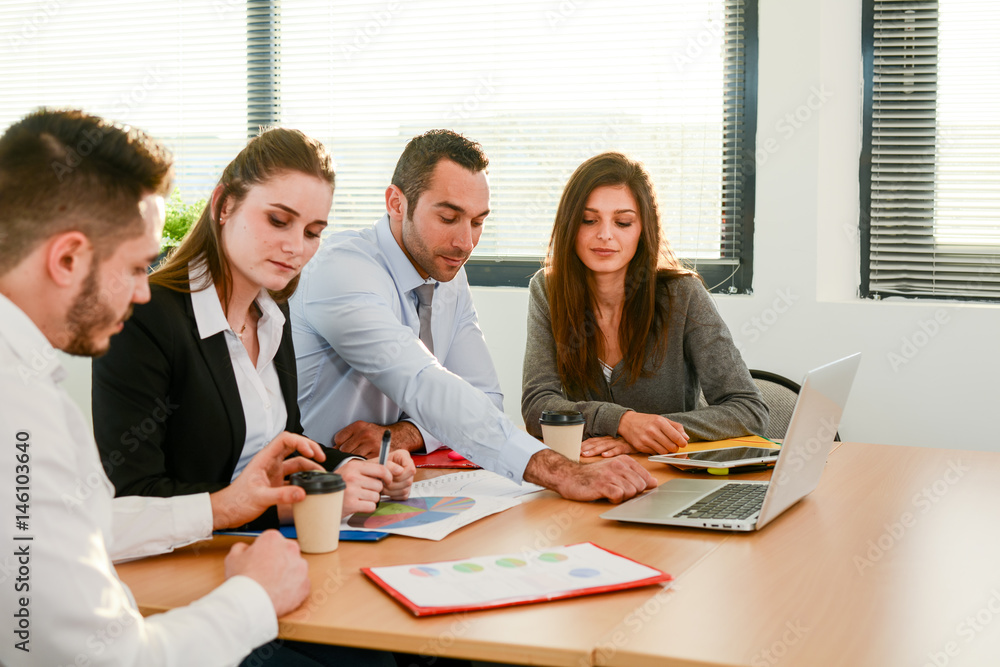 group of four business people with the manager meeting and discussing success with laptop computer in office with sunset backlight group of four business people with the manager meeting and discussing success with laptop computer in office with sunset backlight