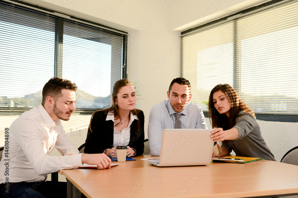 group of four business people with the manager meeting and discussing success with laptop computer in office with sunset backlight group of four business people with the manager meeting and discussing success with laptop computer in office with sunset backlight