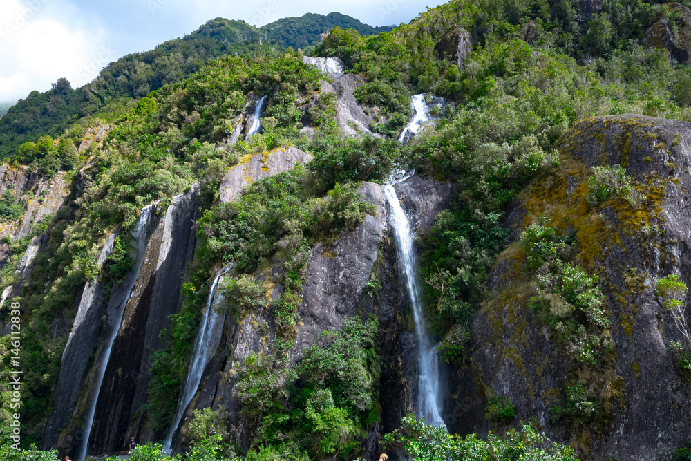 Waterfall at Franz Josef Glacier, Located in Westland Tai Poutini National Park on the West Coast of New Zealand Waterfall at Franz Josef Glacier, Located in Westland Tai Poutini National Park on the West Coast of New Zealand