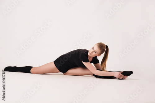 Plasticity. A girl performs an exercise on flexibility.