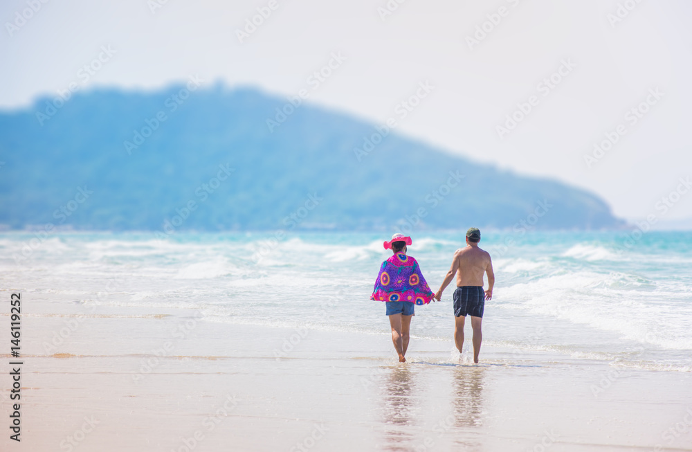 lover hold hand walk on the beach in sea asia