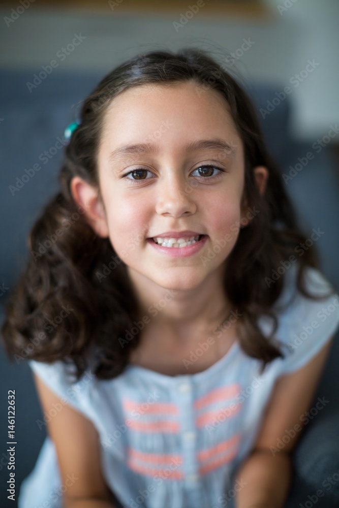 Portrait of smiling girl sitting on sofa in living room Portrait of smiling girl sitting on sofa in living room