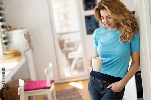 Beautiful blonde woman having morning coffee at home