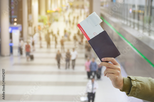 hand hold ticket and passport on airport background