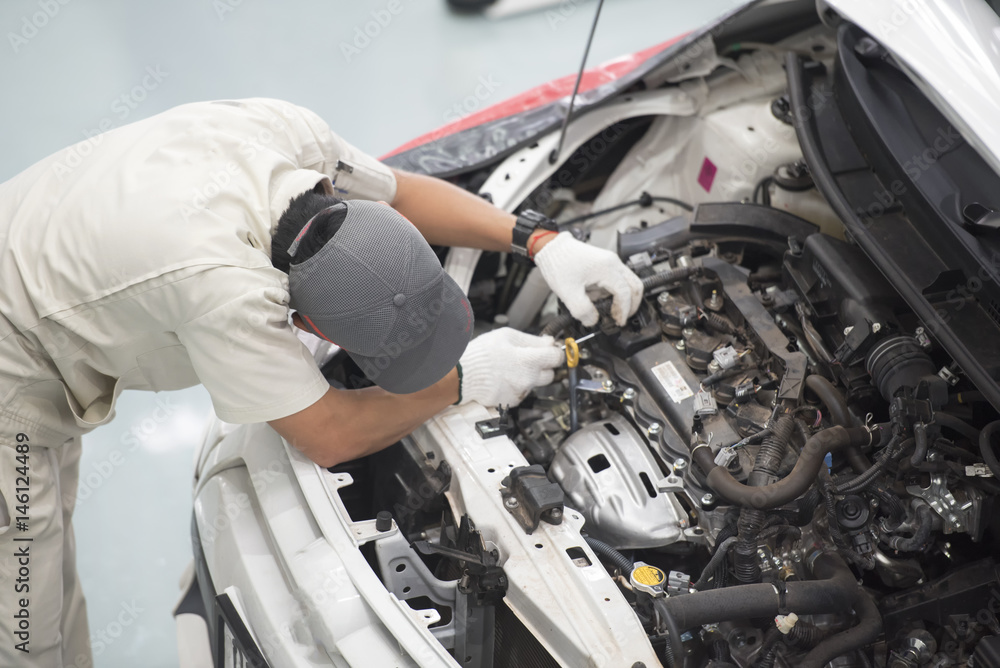 Top view a man fixing a car engine in his garage Top view a man fixing a car engine in his garage
