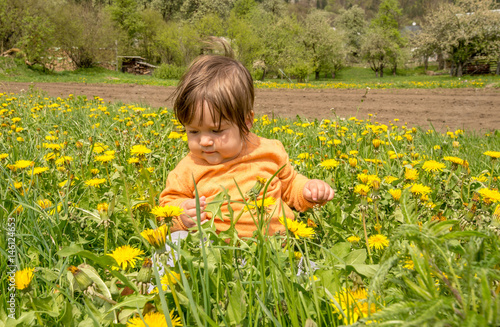 Cute white girl playing on a meadow full with yellow flowers during springtime © Olja