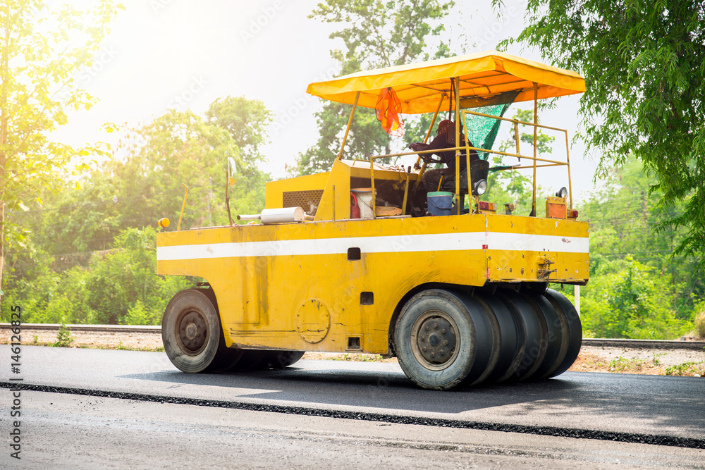 asphalt road construction with machine and steamroller truck at freeway in Thailand.