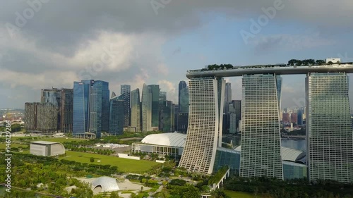 4k travelling aerial shot of Marina Bay Sands with Singapore City Skyline as background during cloudy summer day