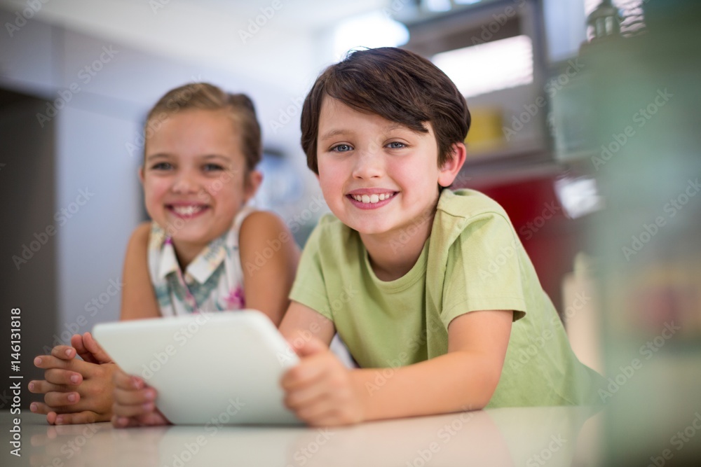 Happy sibling with digital tablet in kitchen Happy sibling with digital tablet in kitchen