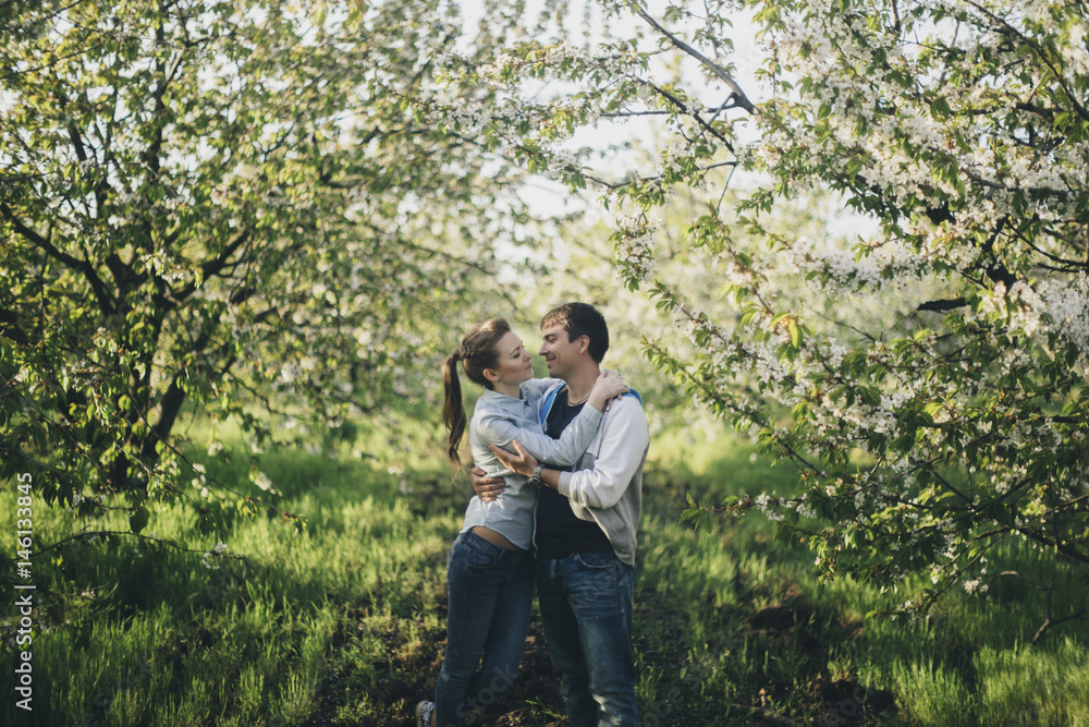 Caucasian couple kissing under flowering trees Caucasian couple kissing under flowering trees