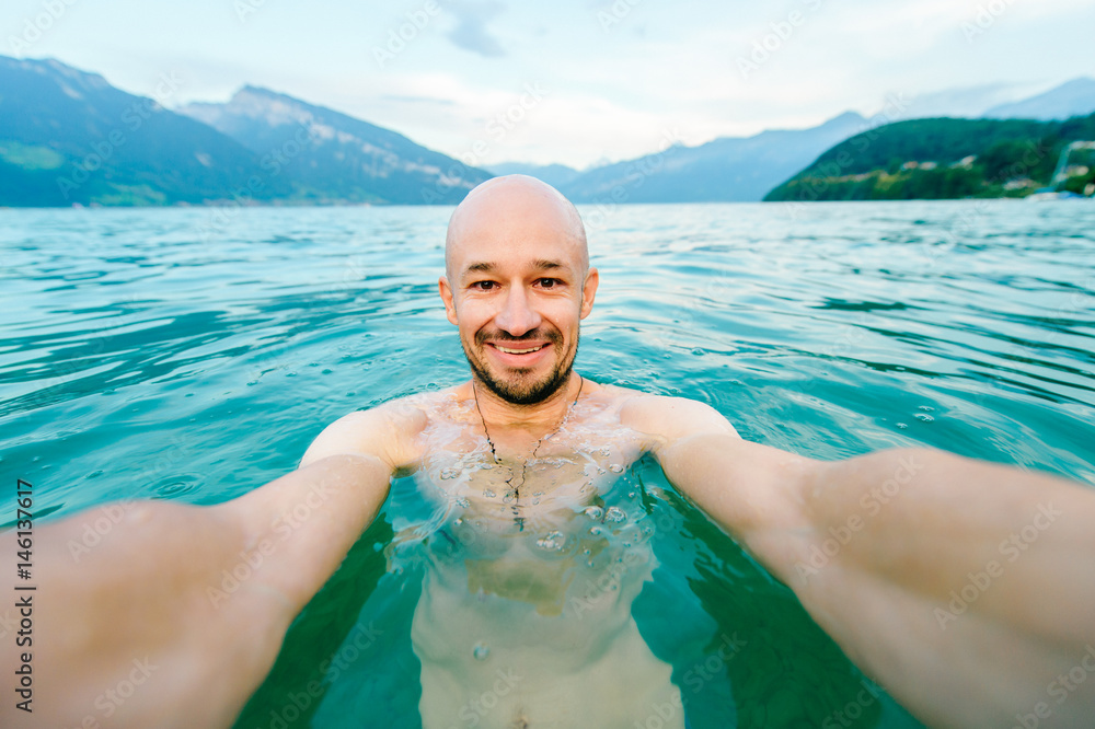 Selfie of a bald happy smiling naked european man swimming in Spitz