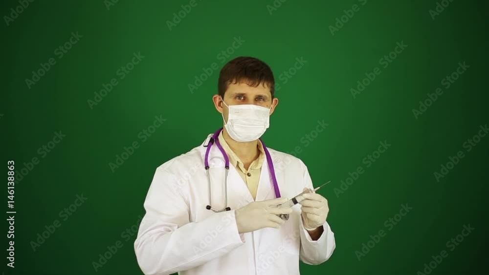 A doctor with a syringe in a medical mask. A doctor with a syringe in a medical mask.