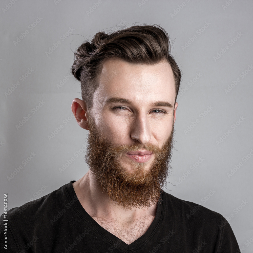 Obraz premium Treacherous and crafty young man isolated on gray background