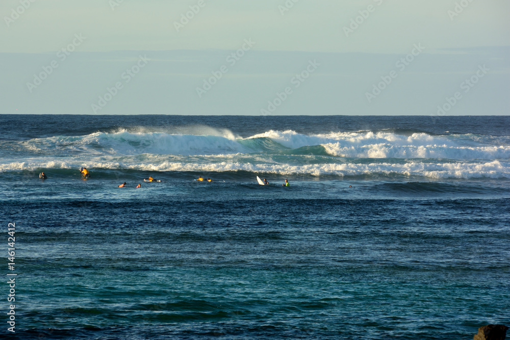 Surfer im Wasser warten auf eine Welle auf einem Riff auf dem Wellen brechen