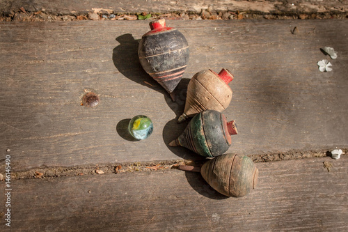 old toys, marbles and wooden top spins  on the floor