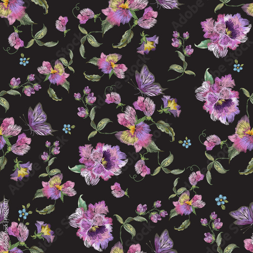 Embroidery trend floral seamless pattern with pansies and forget me not. Vector traditional folk flowers decor on black background for clothing design.