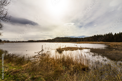 Sun behind clouds over lake  Gjennestadvannet  Stokke  Vestfold in Norway