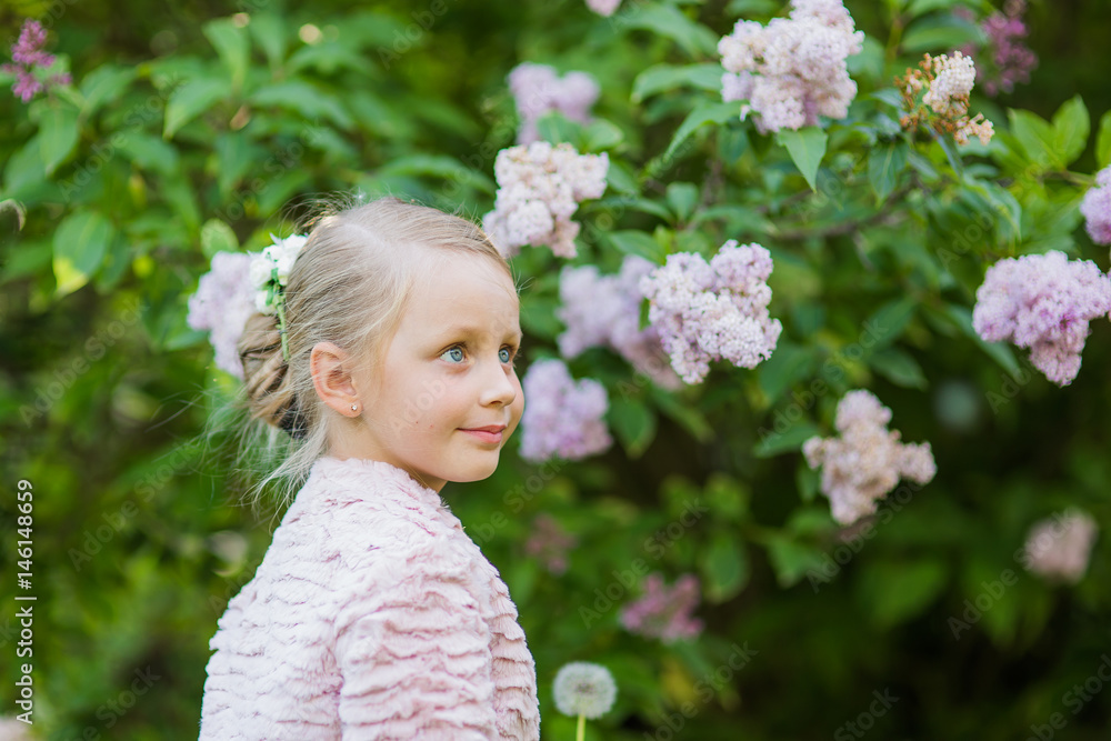 Cute girl walking in the lilac park. Summertime Cute girl walking in the lilac park. Summertime