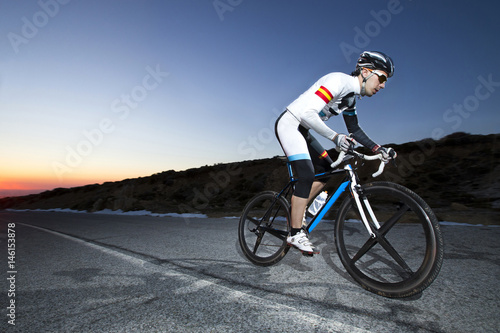 Fototapeta Naklejka Na Ścianę i Meble -  Cyclist man riding mountain bike at sunset on a mountain road