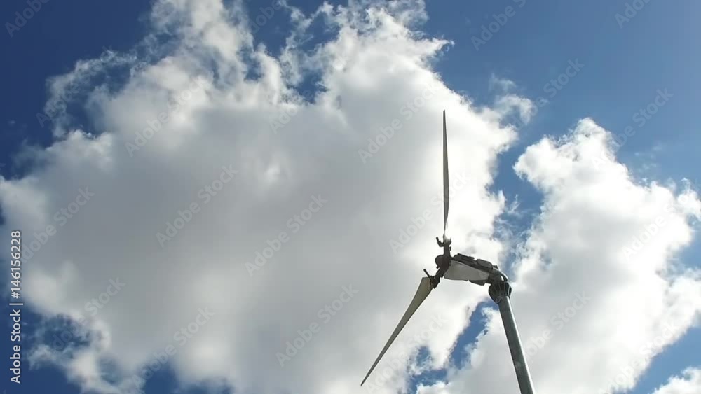 The camera slowly moves around the wind power generator against the sky with clouds. The camera slowly moves around the wind power generator against the sky with clouds.