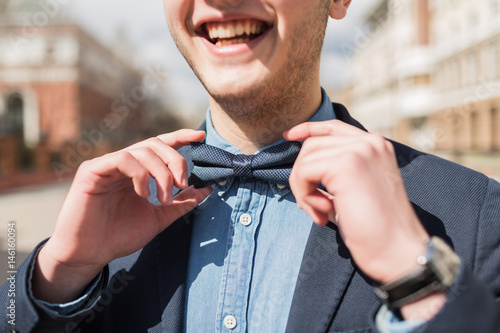 young man is holding a bow tie photo