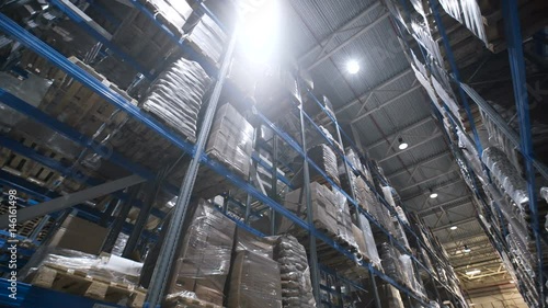 Wallpaper Mural Camera moves up on shelves of cardboard boxes inside a storage warehouse. Industrial warehouse with boxes. Large warehouse logistics terminal Torontodigital.ca