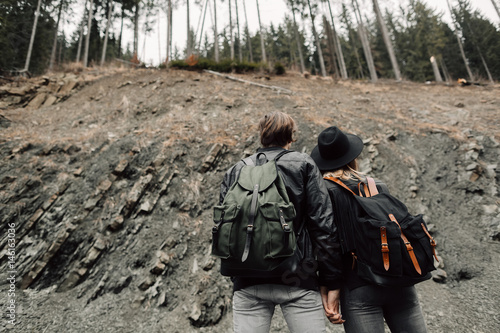 The couple are traveling. Boy and girl with backpacks travel. A man and a woman near the cliff. The couple are back. Travel © Konstantin