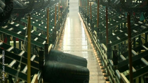 Smoked tires falls on conveyor belt from curing presses at the tires production plant